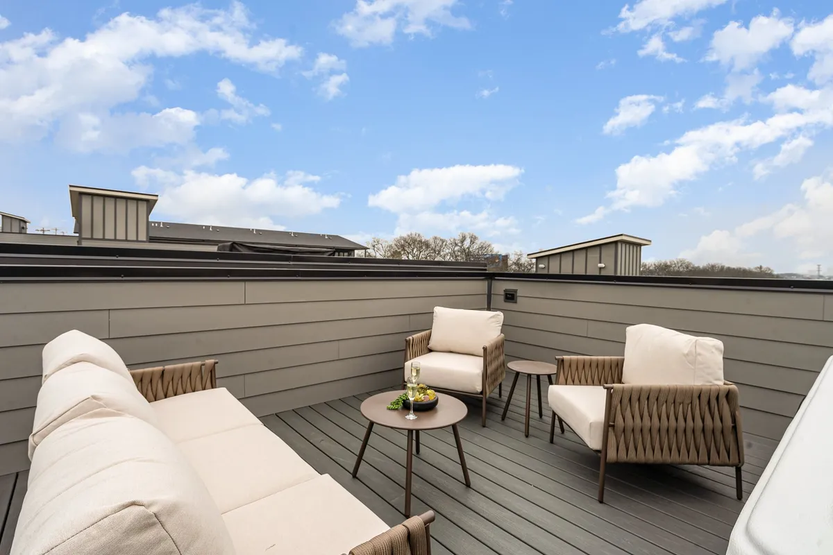 A cozy rooftop lounge area is depicted, complete with comfortable outdoor seating, a small coffee table, and unobstructed views of the open sky above. The peaceful ambiance suggests a perfect spot for stargazing, sunrise coffees, or unwinding in the evening, in line with the section's references to city gazing and starry night soaks.