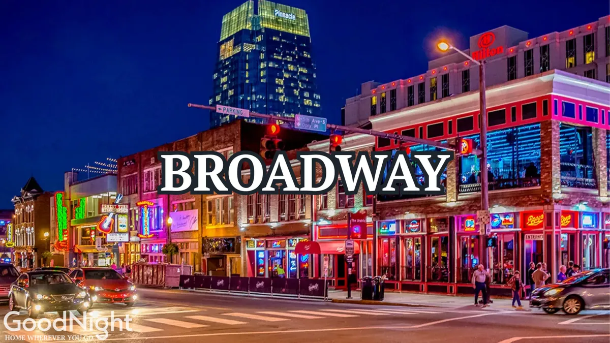 A vibrant exterior nighttime scene of Nashville's Broadway, featuring bright neon signs, historic buildings, a bustling street, and crowds of people enjoying the city's energetic nightlife. The atmosphere is charged with excitement, perfectly capturing the essence of Nashville's renowned live music and party scene.